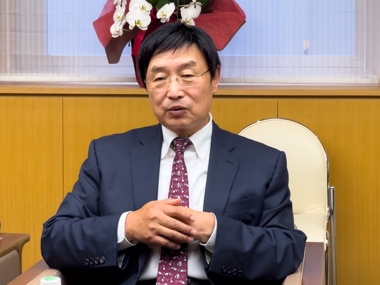 スーツを着た男性自動的に生成された説明